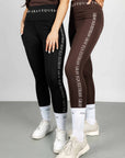 Two models standing next to each other. The model on the left is wearing our brown renew vest and black riding leggings. The model on the right is wearing our nude vest and brown renew leggings.